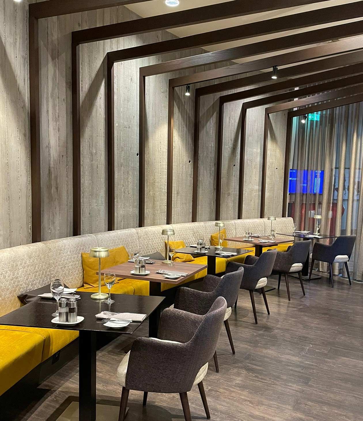 Hotel-Restaurant mit Sichtbetonwand und gelber Sitzbank