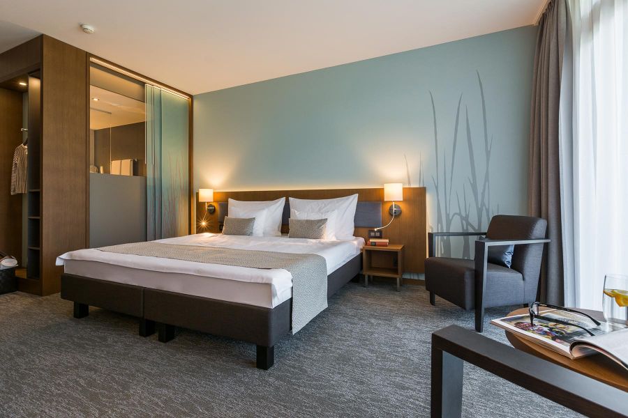Hotelzimmer Deltapark mit Doppelbett und sanften Blautönen