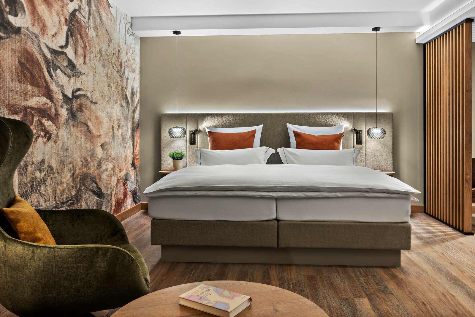 Prinzess-Zimmer Churfürstenhof Bad Birnbach zeigt großes Doppelbett dekorative florale Wandtapete und bequemen Sessel