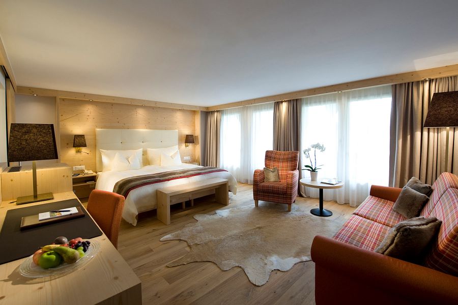 großzügiges Hotelzimmer mit Holzverkleidungen und warmer Beleuchtung