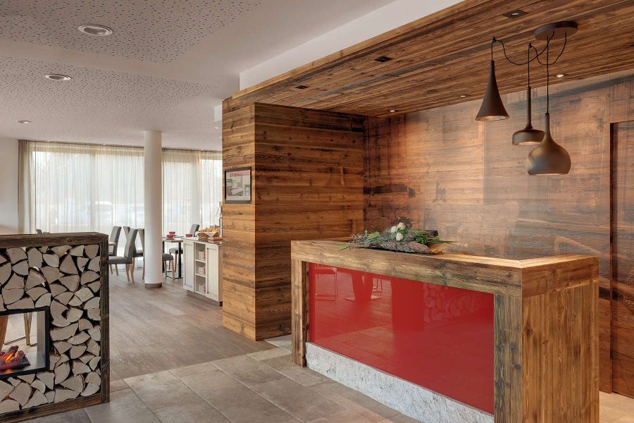 Rezeptionsbereich mit Holz und roten Akzenten im Hotel Traumschmiede