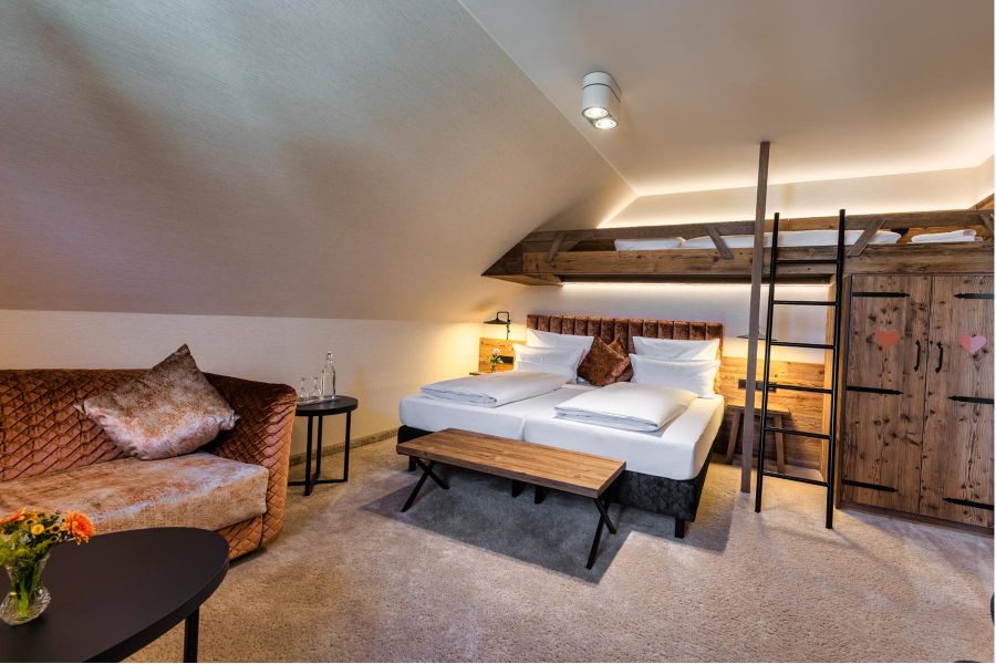 geräumiges Hotelzimmer mit Couch und Hochbett im Hotel Schaefflerwirt
