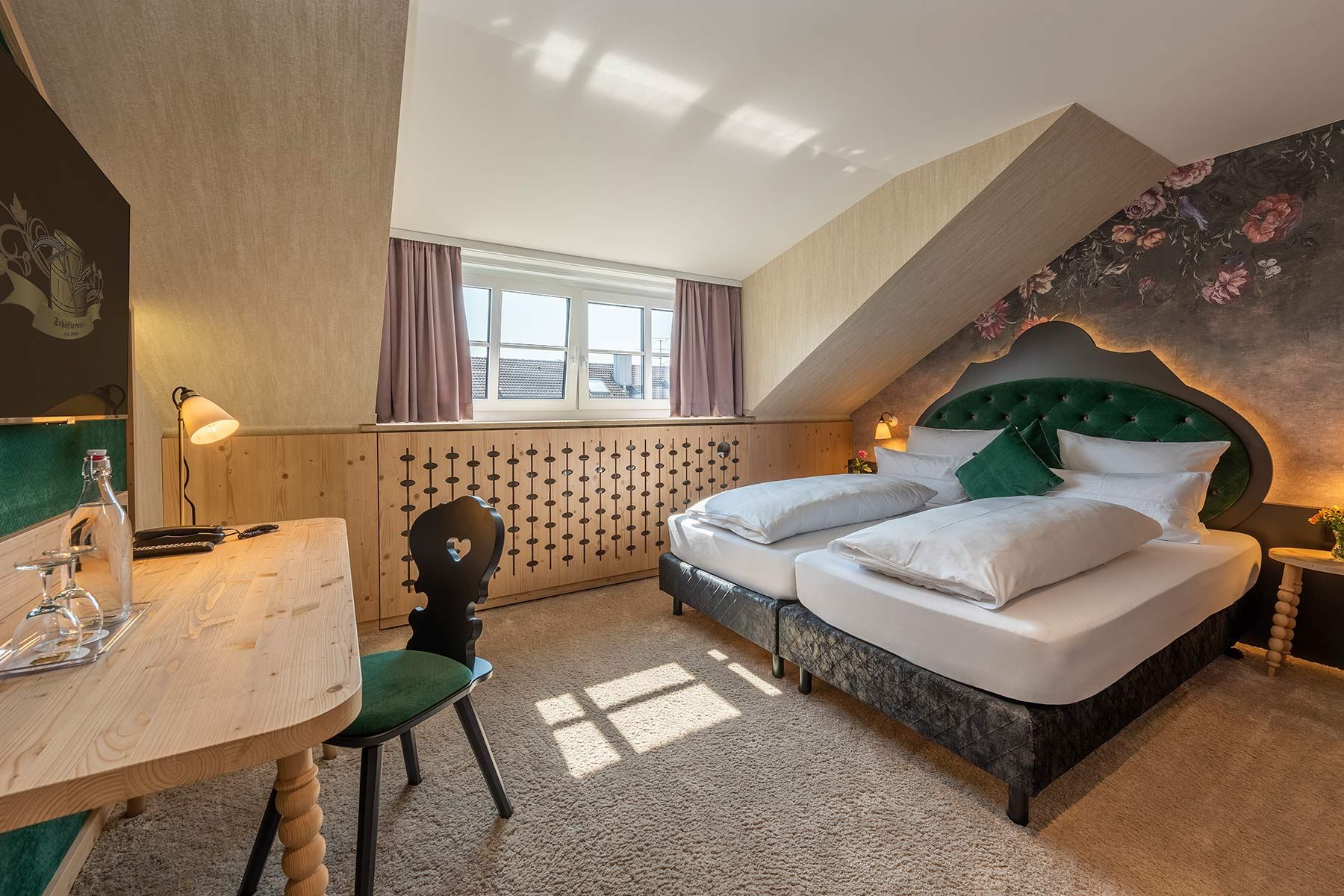 Hotelzimmer mit floraler Tapete, grünen Akzenten und Holzverkleidungen im Hotel Schaefflerwirt