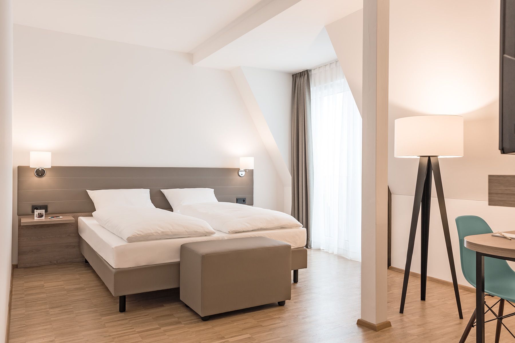 Modern und hell durch die APPIA Contract GmbH eingerichtete Hotelzimmer mit den entsprechend passenden Leuchten im Hotel Trezor in Singen.