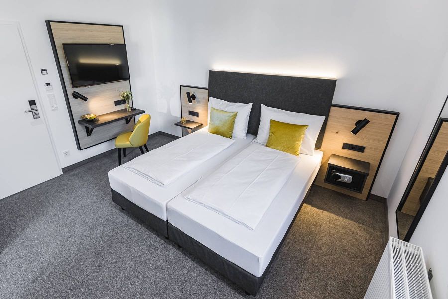 Hotelzimmer mit Doppelbett, Schreibtisch und TV im Stadthotel in Oberndorf