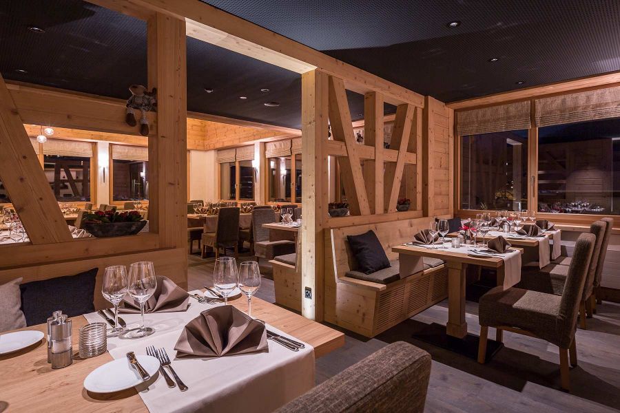 Hotel Restaurant im durchgängigen Holzdesign, warme Räume durch Stühle mit Stoffbezug.