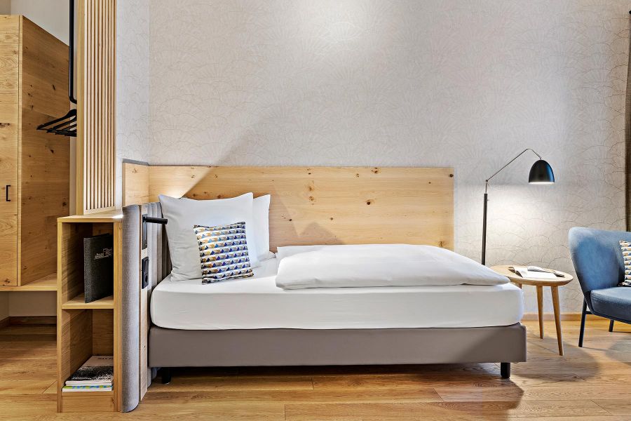 Garderobe mit Abtrennung zum Bett in Form von Lamellen aus Holz in Kreuth