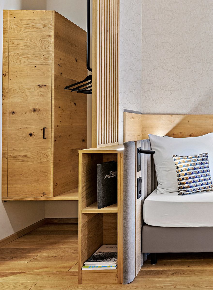 Garderobe mit Abtrennung zum Bett in Form von Lamellen aus Holz