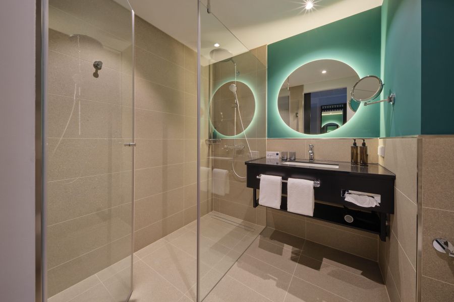 Badezimmer mit Dusche und beleuchteten Spiegel