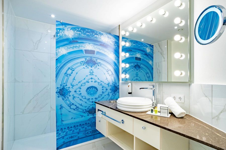 Badezimmer in hellem Design mit folierter Duschwand in blau