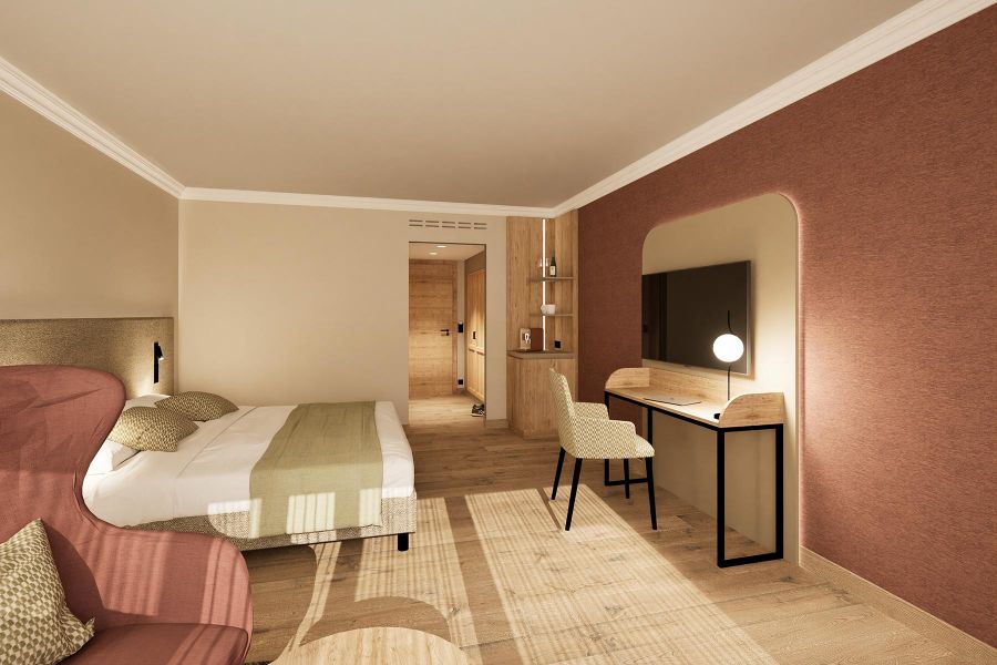 Gemütliches Doppelbett mit Akzentkissen in Hotelzimmer Churfürstenhof Bad Birnbach neben Schreibtisch und Wandfernseher