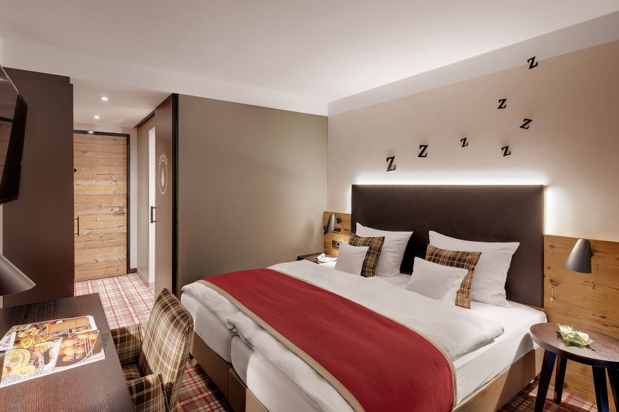 gemütliches Schlafzimmer in braun und rot im Hotel Traumschmiede