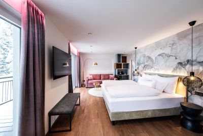 Hotelzimmer mit Bett und pinken Sofa
