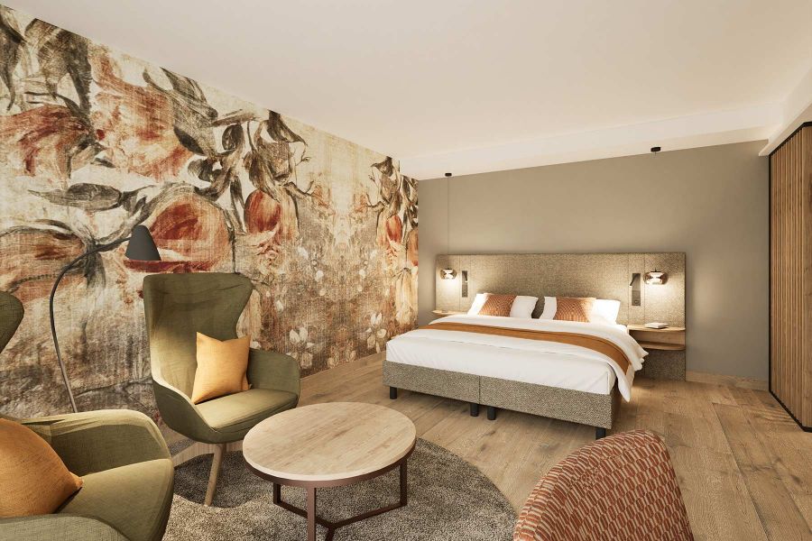 Gesamtansicht Prinzess-Zimmer Churfürstenhof Bad Birnbach zeigt großes Doppelbett dekorative florale Wandtapete und bequemen Sessel