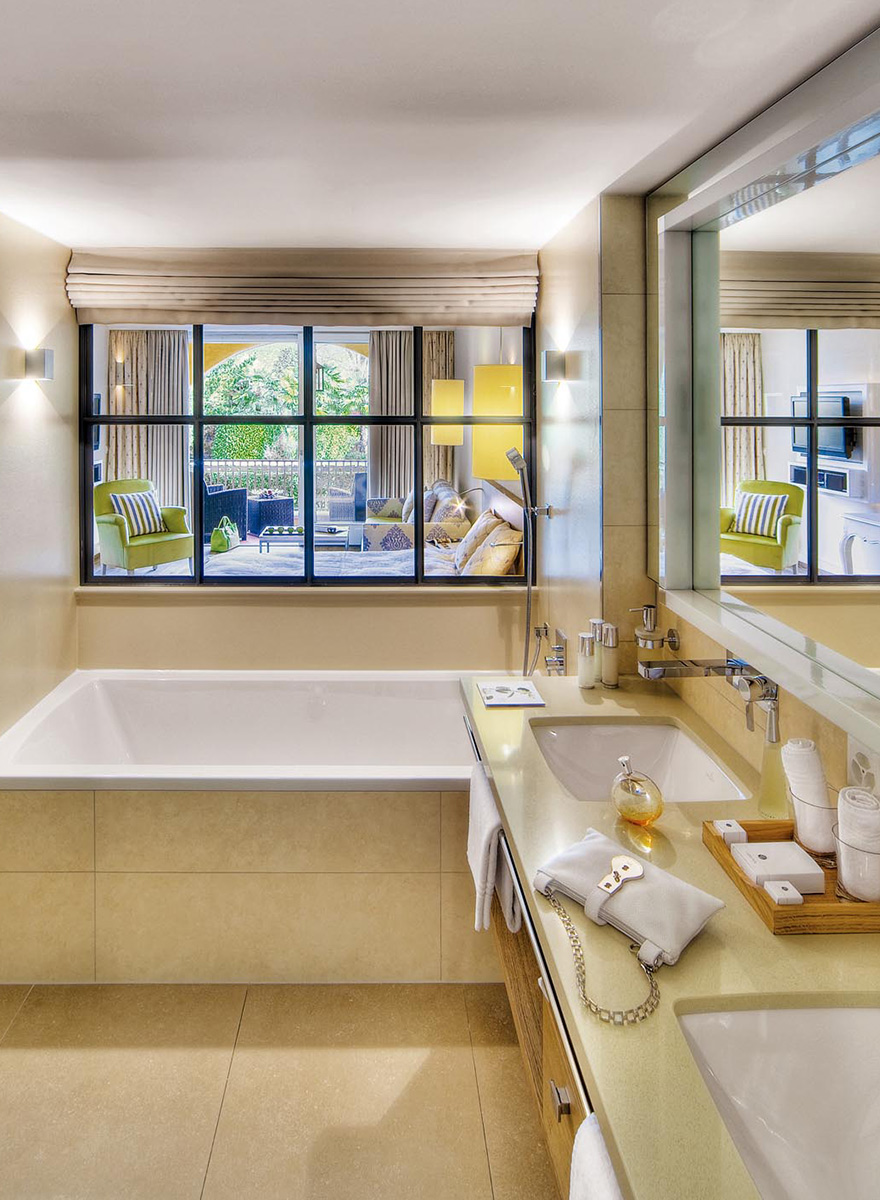 Badezimmer mit Badewanne und doppeltem Waschtisch in hellen Farbtönen