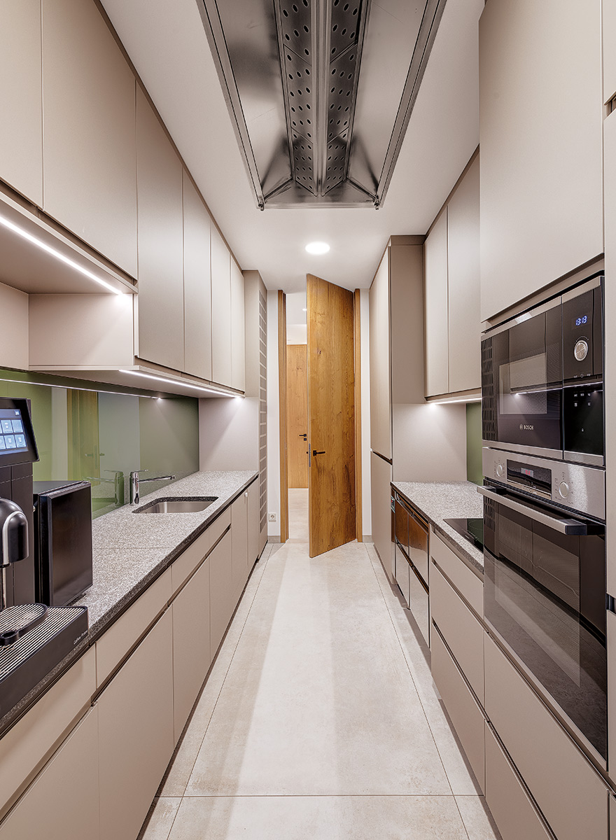 lange Küchenzeile mit Kaffeemaschine und Ofen sowie Mikrowelle geplant und gestaltet von Appia Contract GmbH