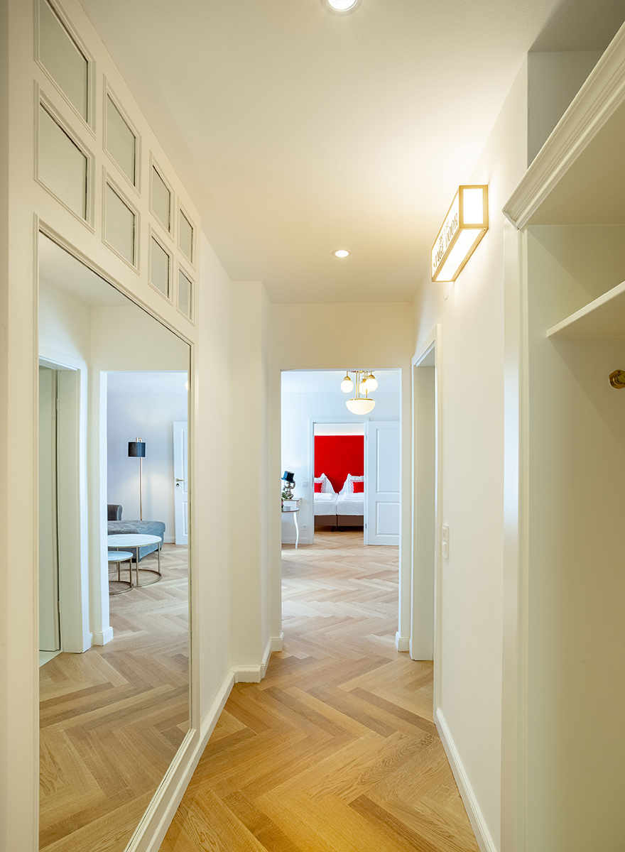 gro&szlig;z&uuml;giger Flur mit Fischgr&auml;tparkett in der Suite des Theaterhotels