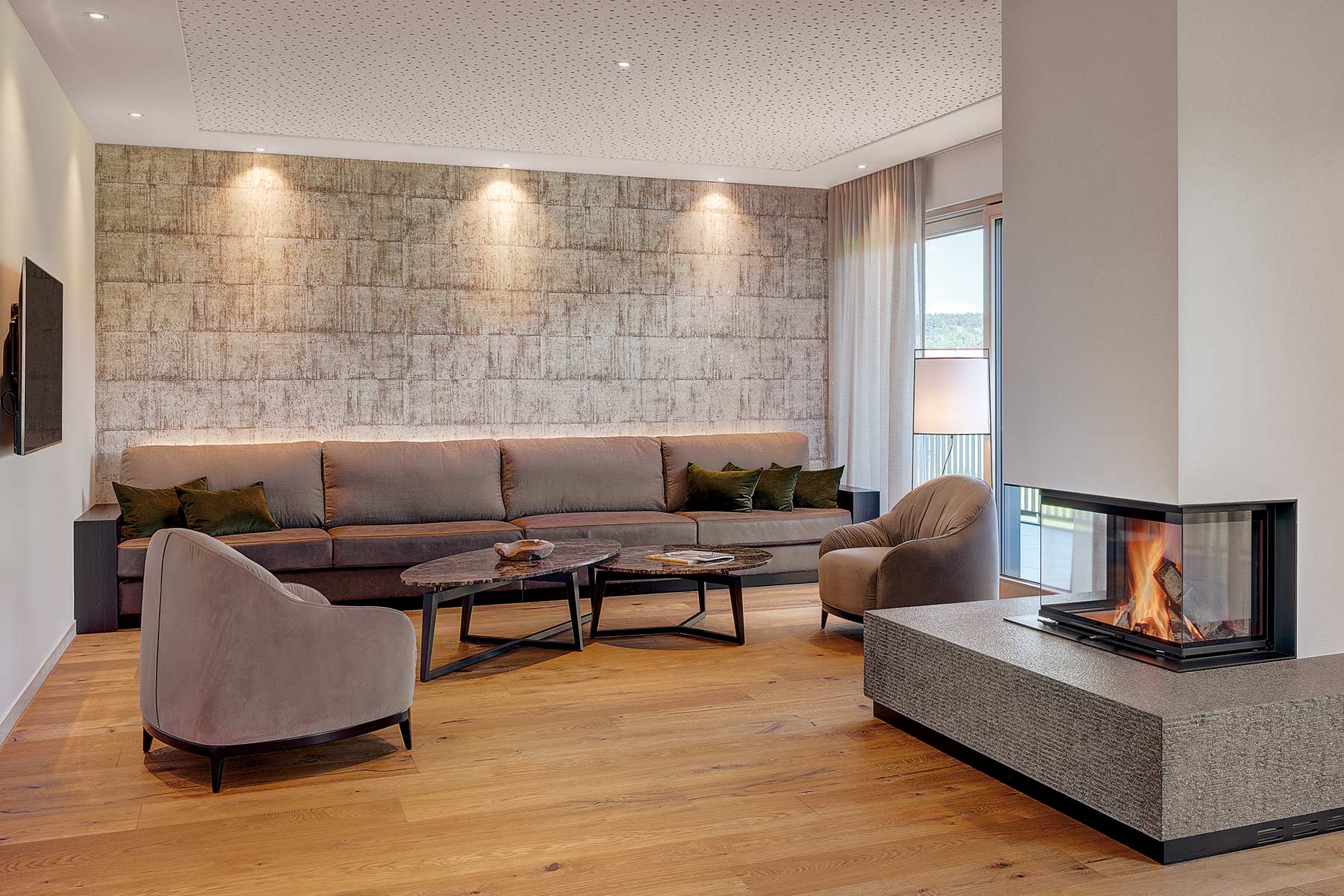 großzügige Lounge mit Kamin und Sesseln 