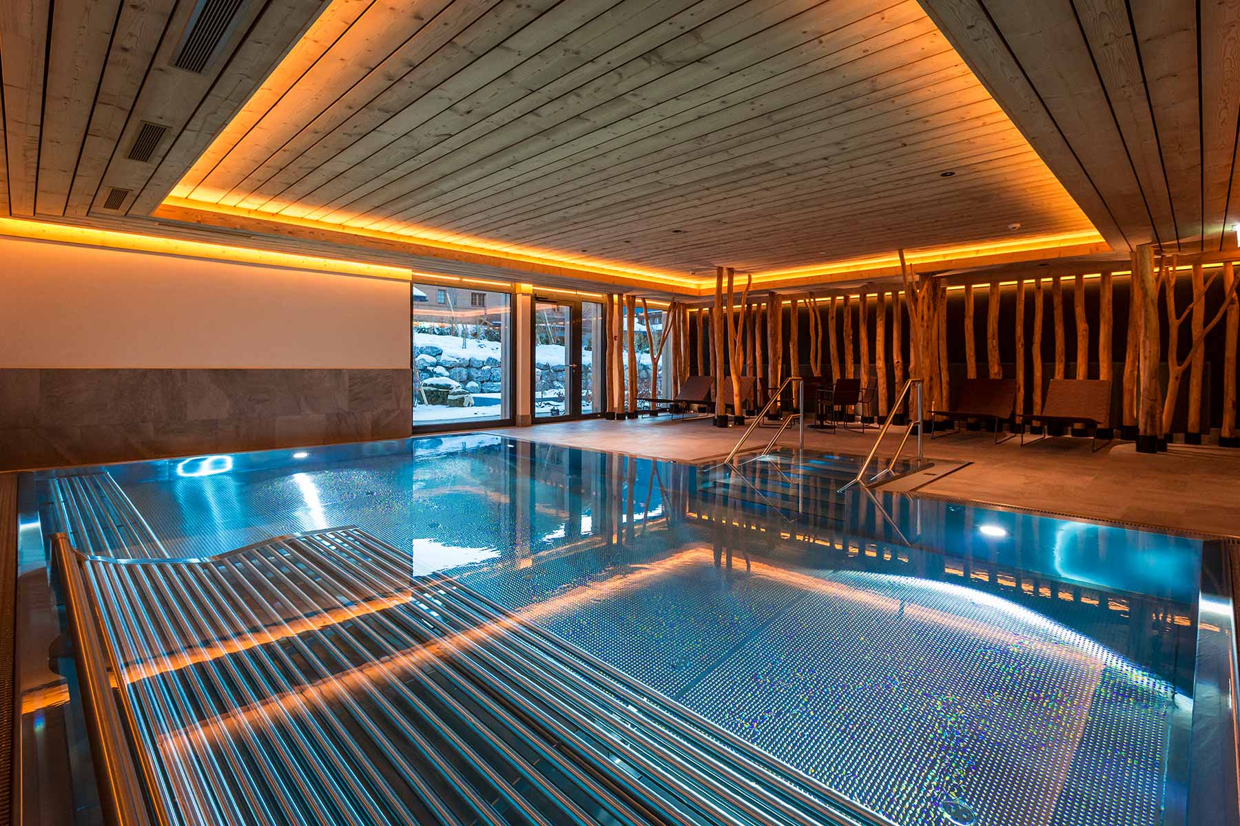 Indoorpool im Hotel mit Holzverkleidung im Raum schafft eine angenehme warme Hotel Atmosph&auml;re
