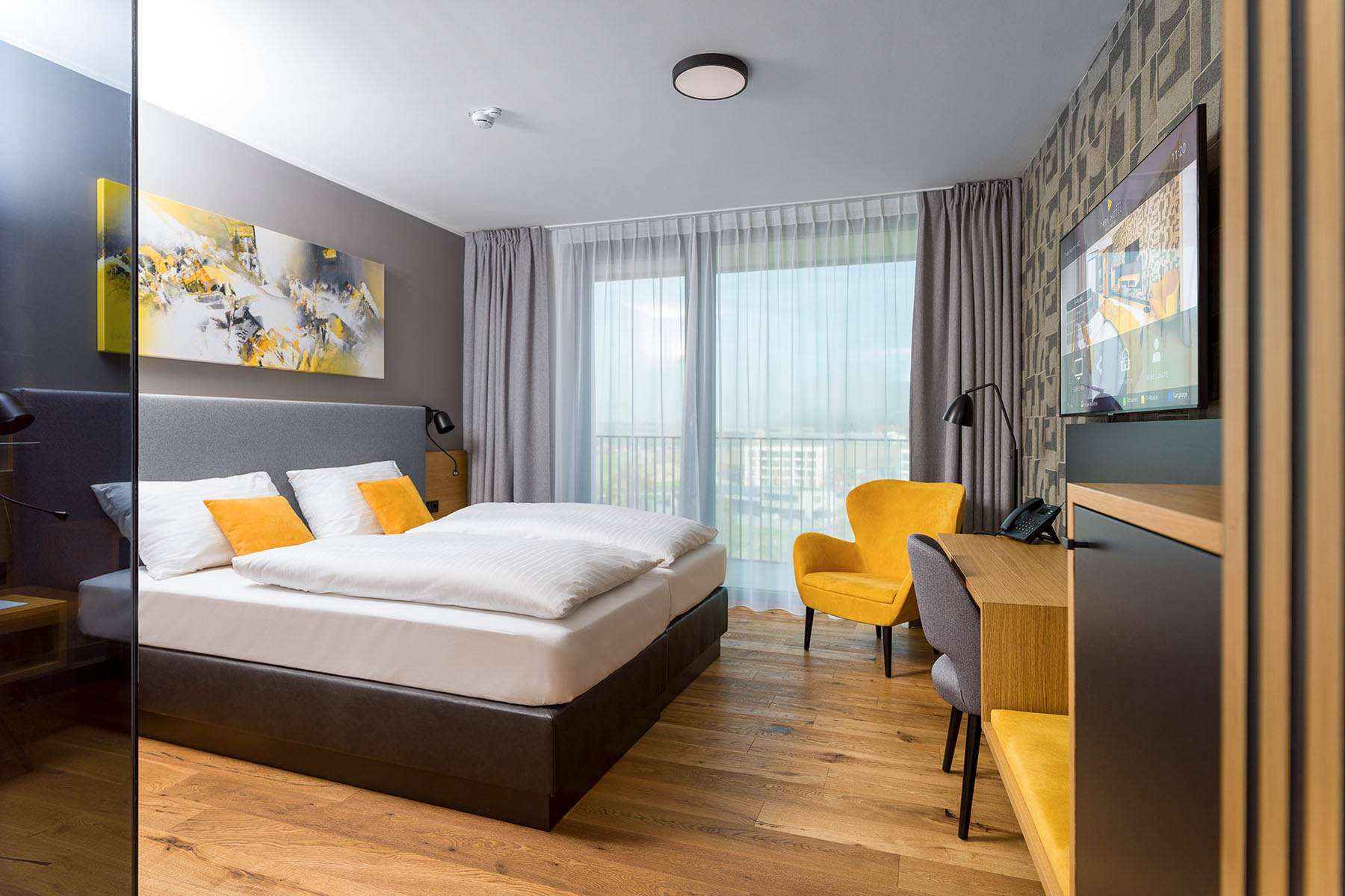 93 Hotelzimmer mit gelben Sesseln