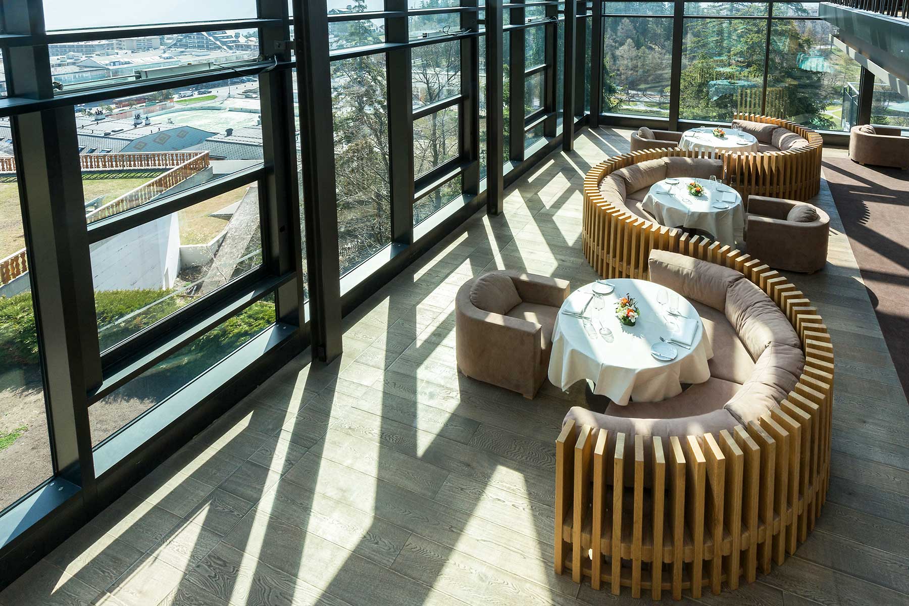 Moderne Sitzgelegenheit in geschwungen verbauter Lamellenoptik mit großen Panorama-Fenstern