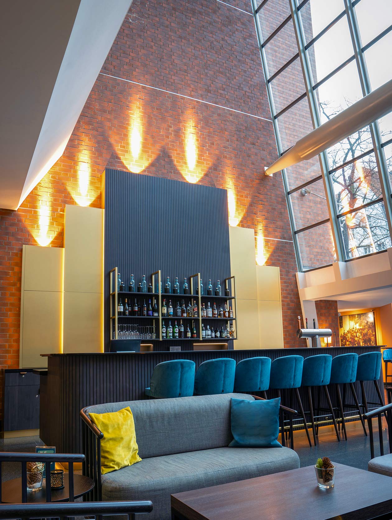 Kombination aus gem&uuml;tlicher Lounge und stilvoller Bar mit blauem Samt und Goldakzenten