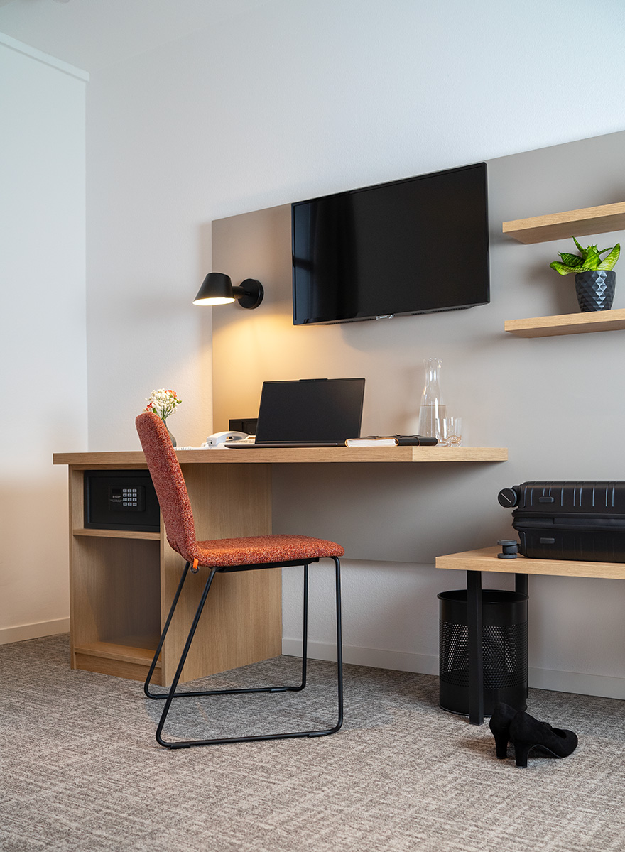 TV zwischen Schreinermöbel, Schreibtischplatte, Schreibtischunterschrank und Wandregale aus hellem Holz