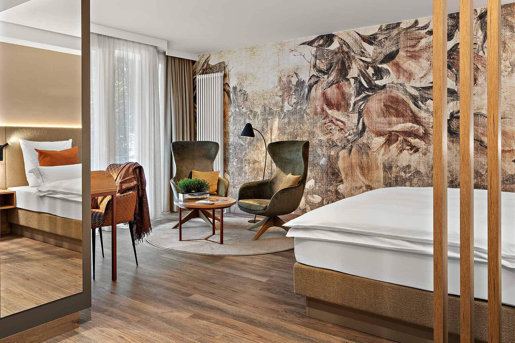 Gesamtansicht Prinzess-Zimmer Churfürstenhof Bad Birnbach zeigt großes Doppelbett dekorative florale Wandtapete und bequemen Sessel