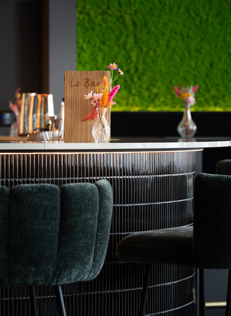 Tresendetail mit Fliesenfront und Cocktailglas sowie kleiner Dekoration auf Tisch