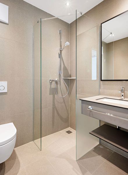 Badezimmer mit Dusche und Waschtisch in natürlicher Farbgebung