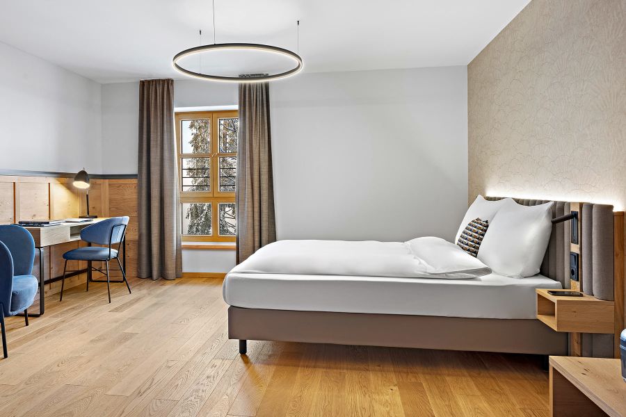 Bett mit indirekter Beleuchtung und Schreibtisch in der Tagungsstätte Schloss Ringberg
