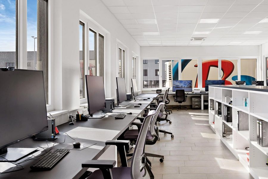 Arbeitsplätze am Fenster und Firmenlogo im Hintergrund