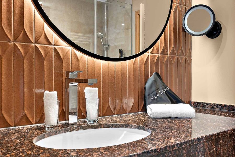 Dunkle Arbeitsplatte und helles Holzregal bestimmen Design im Bad Churfürstenhof Bad Birnbach