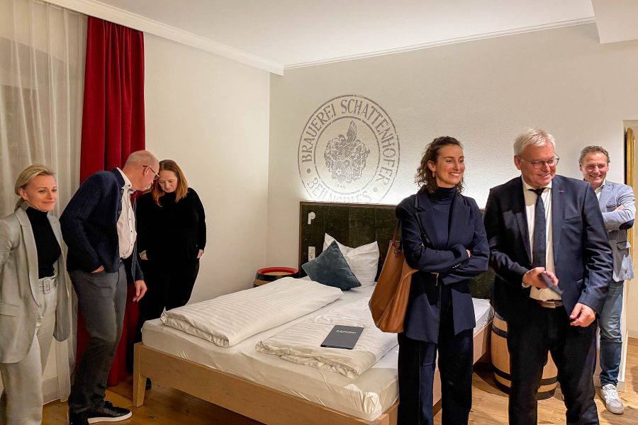 Premium Doppelzimmer mit roten Vorhängen, grünem Bettkopfteil und Holz