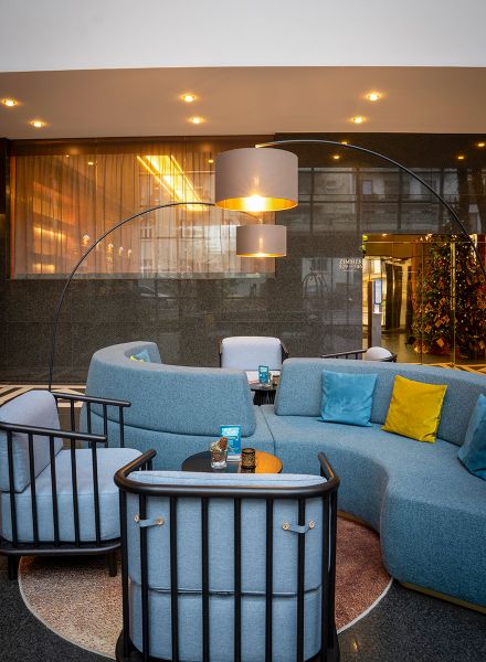 Lounge mit blau geschwungenen Polstermöbeln im Berliner Aparthotel Derag Living Hotel Weißensee