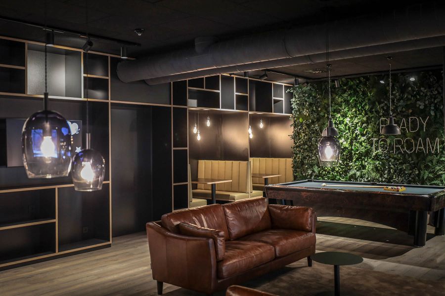 Lobby-Einrichtung mit Billardtisch und Pflanzen an der Wand