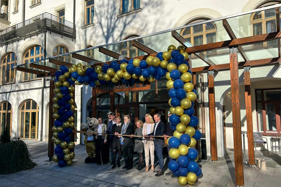 Mehrere Personen stehen vor dem Eingang des Parkhotel Biberach und durchschneiden gemeinsam ein Band zur offiziellen Eröffnung.
