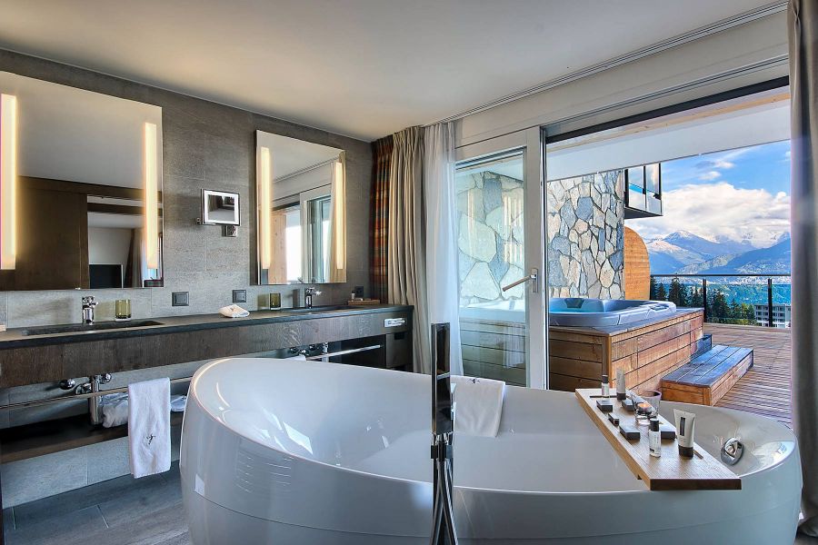 Freistehende Badewanne im großräumigen Badezimmer mit Blick auf die Berge