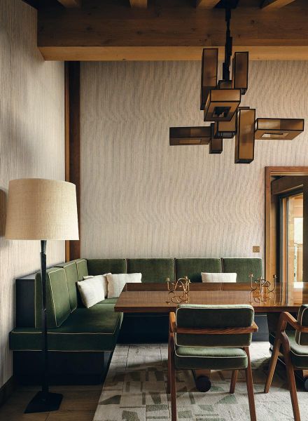 elegante Sitzecke mit einem grünen Sofa und extravagante Leuchte in St. Moritz