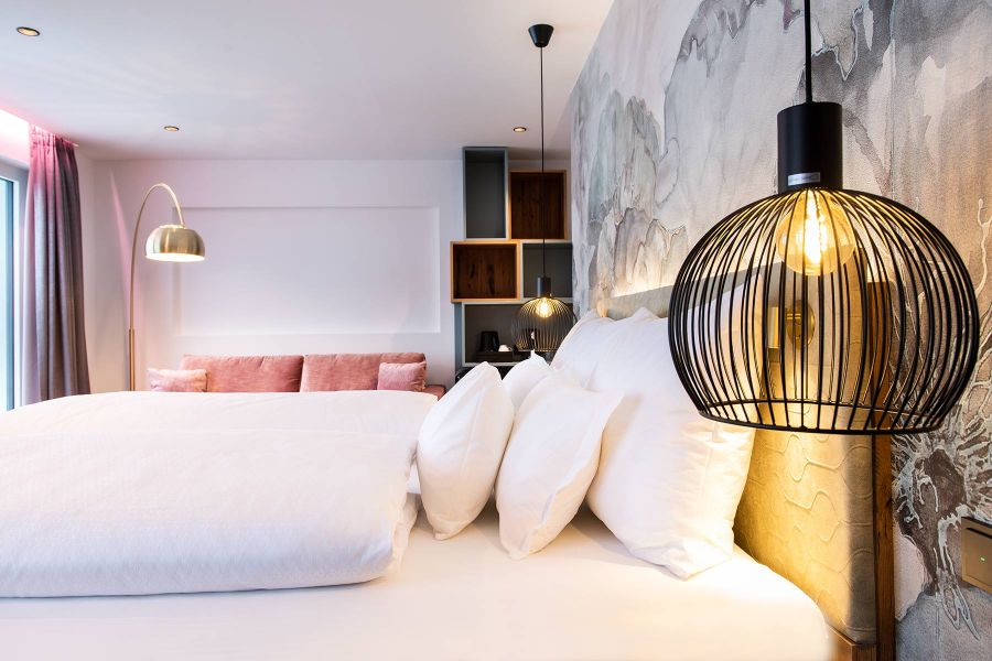 Bett mit Pendelleuchten und Stehlampe