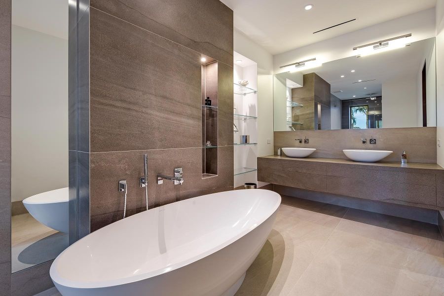 Badezimmer mit Badewanne und großem Spiegel 