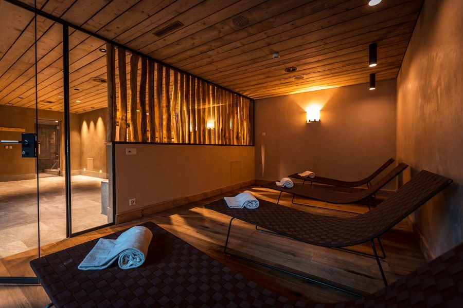 Interior für Wellness und Spa mit Liegen, farblich passenden Handtüchern und Rundhölzer sorgen für ein Urlaubsfeeling.