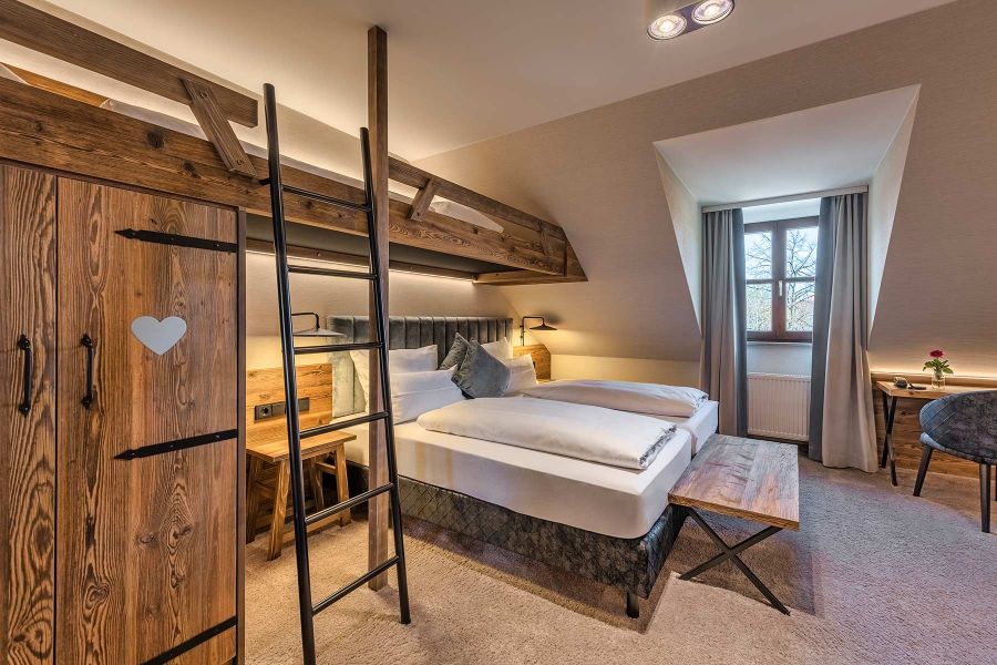 Hotelzimmer mit Hochbett und rustikalem Ambiente 