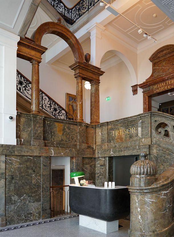 Historischer Tresorraum des Rosewood in München als Empfangsbereich mit massiver Natursteinarchitektur schwarzem Tresen und prägenden Rundbögen