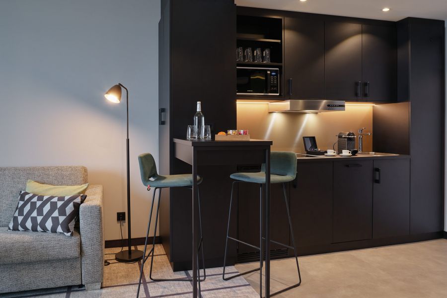 kleine Küchenzeile in Hotelzimmer mit Hochstühlen