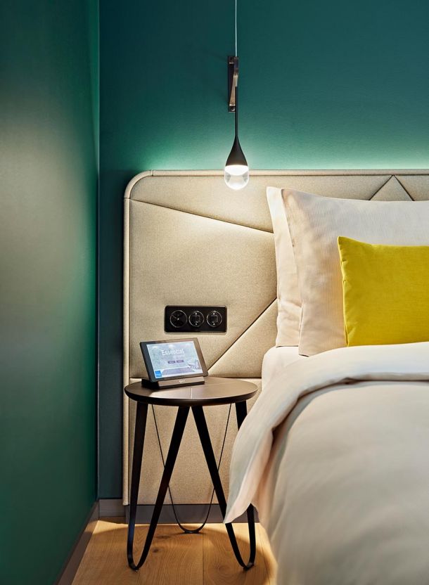 Hotelbett mit Beistelltisch und Leuchte