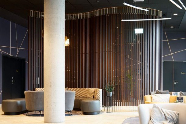 Eingangsbereich im Dorint Business Campus Garching mit großzügiger Lobbyzone Holzlamellenwand und Sitzbereich unter hoher Decke