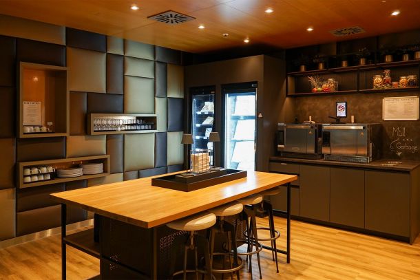 Professionell gestaltete Küche im Novotel München Airport mit Arbeitsinsel Holzoberflächen Küchenzeile Gerätefronten Rückwandpaneelen und warm abgestimmtem Lichtkonzept