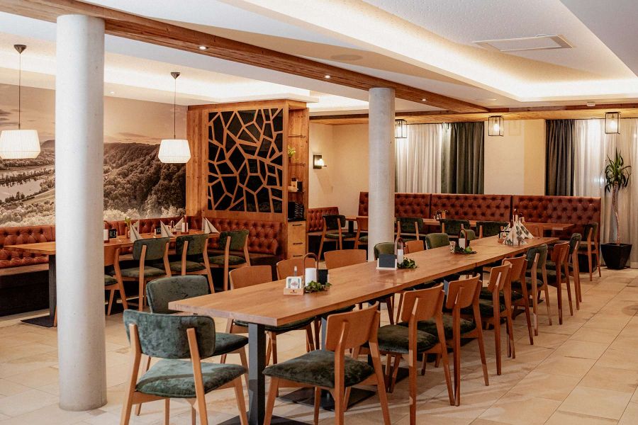 Tische im Saal mit dekorativen Blumen, Kerzen und umstehenden Stühlen im Gasthof Hummel in Stammham