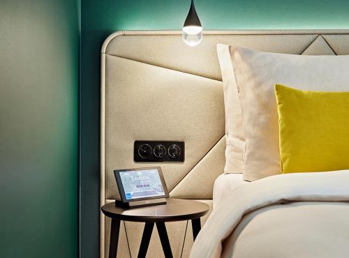 Hotelbett mit Beistelltisch und Leuchte